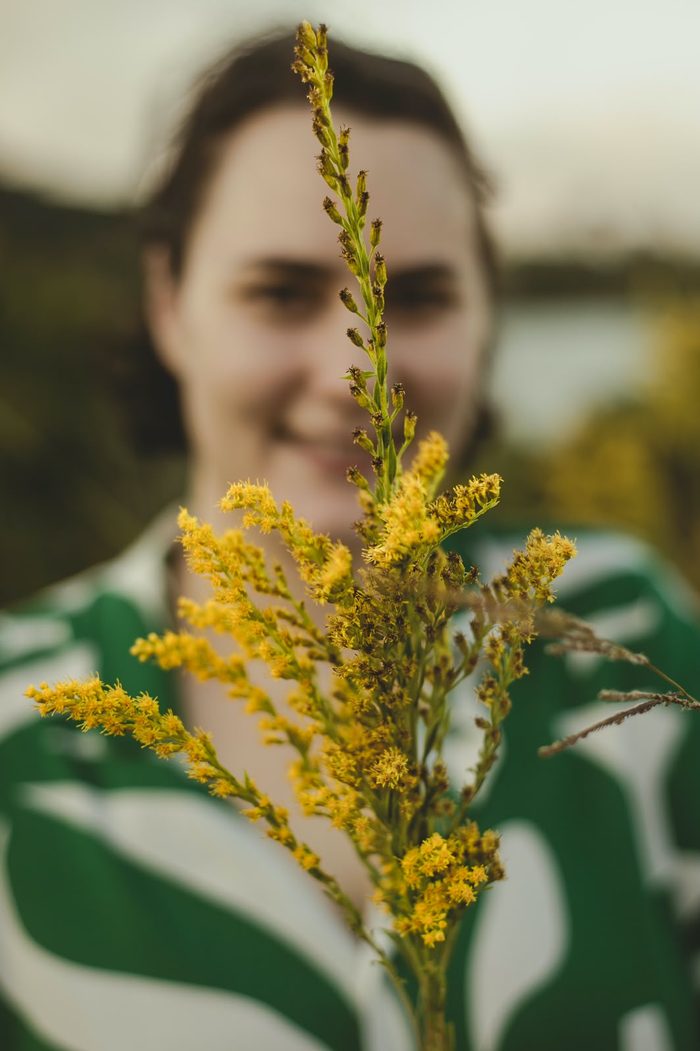 Portrait of Elinor Ackerman holding a sprig of goldenrod